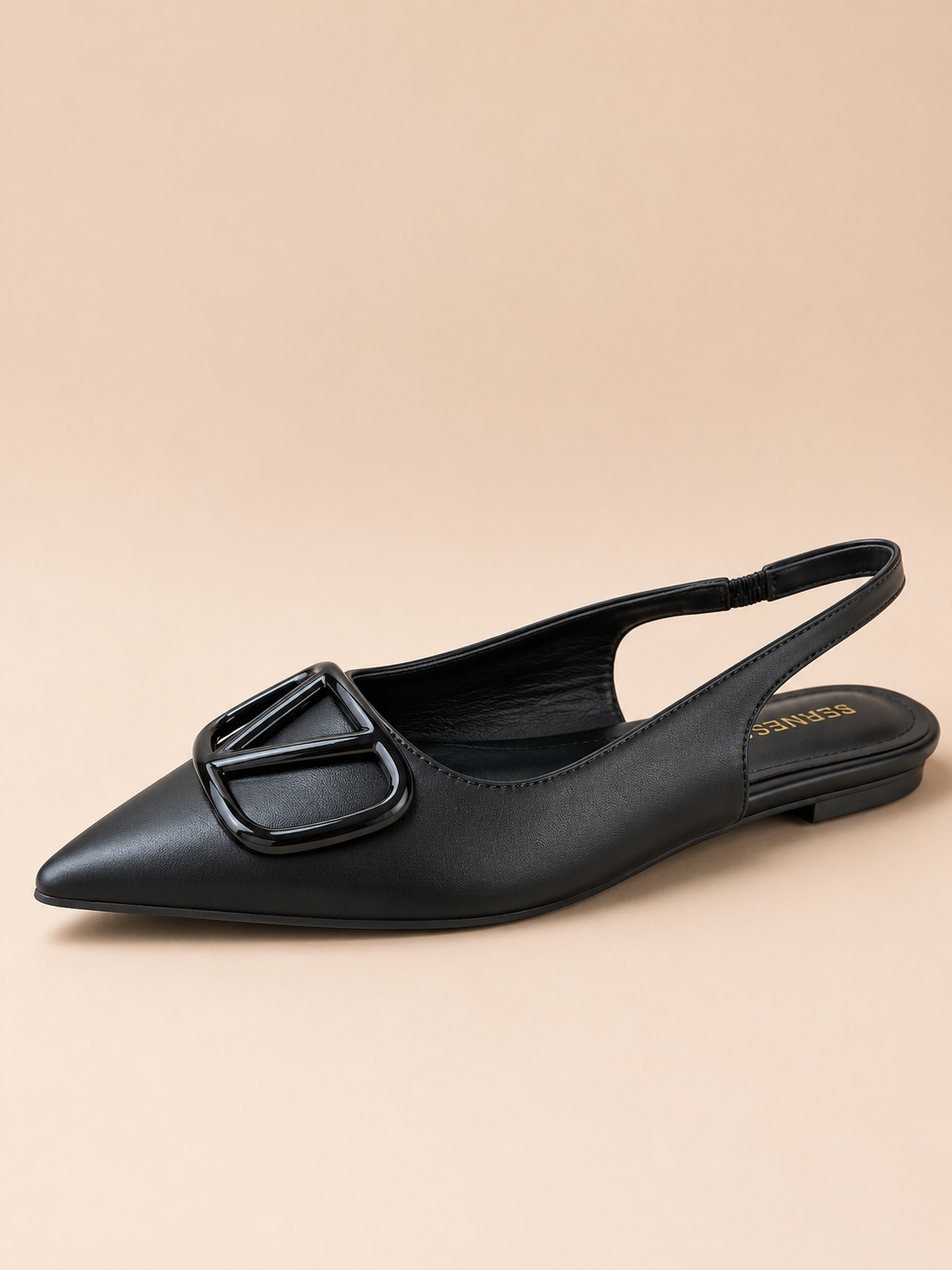 Black slingback flat shoe on a beige background