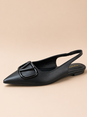 Black slingback flat shoe on a beige background
