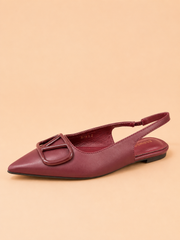Maroon flat shoe with a slingback design on a beige background