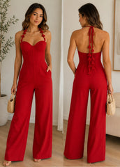 Woman wearing a red jumpsuit with a plant and couch in the background